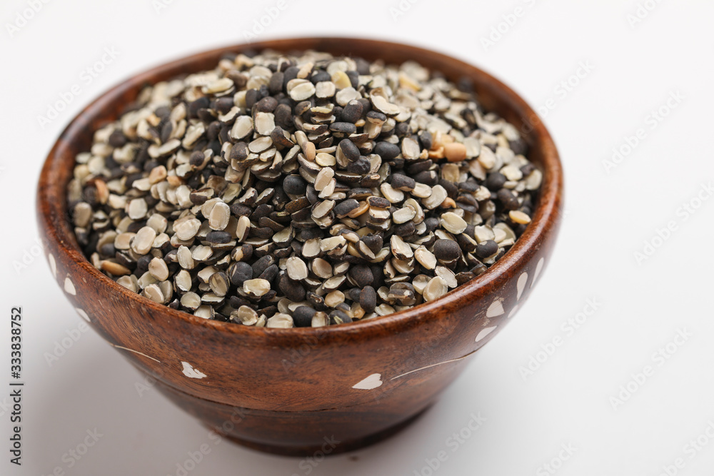 Split Black Lentil Also Know as Black Gram, Black Urad Dal, Vigna Mungo, Urad Bean in wooden bowl on white background Split Black Lentil Also Know as Black Gram, Black Urad Dal, Vigna Mungo, Urad Bean in wooden bowl on white background