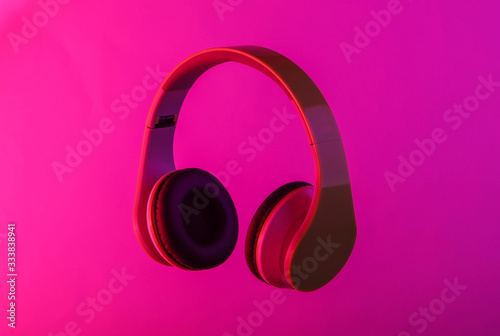 Modern stereo headphones with neon vibrant pink glow.