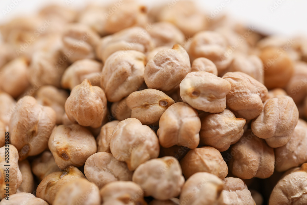 Uncooked dried chickpeas in wooden bowl