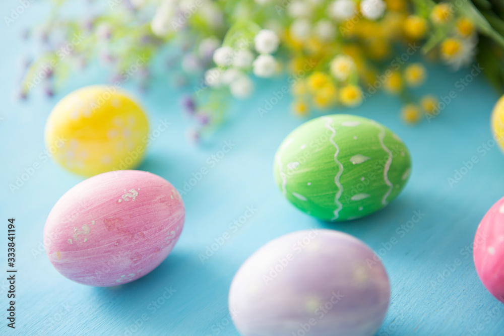 Colorful easter eggs with flowers on a blue wooden table background Colorful easter eggs with flowers on a blue wooden table background