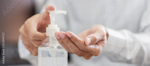 Man hands using wash hand alcohol gel or sanitizer bottle dispenser, against Novel coronavirus or Corona Virus Disease (Covid-19) . Antiseptic, Hygiene and Health concept