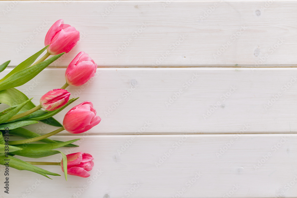 Bouquet of pink tulips on white wooden background. Top view, copy space