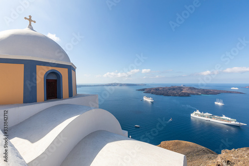Church of Fira town at Santorini island, Greece. Summer travel landscape, amazing white architecture and cruise ships in blue sea 