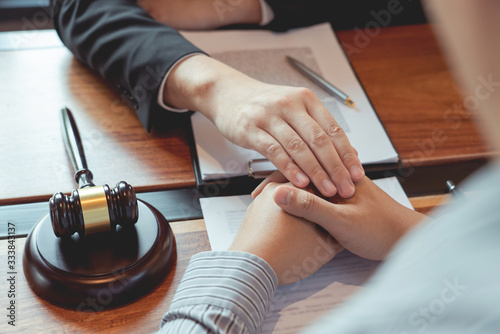 Lawyer working with client discussing contract papers with brass scale about legal legislation in courtroom, consulting to help their customer.
