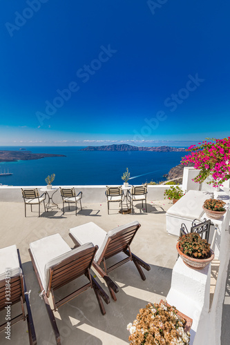 White chaise lounges on the terrace with sea view. White architecture on Santorini island, Greece. © icemanphotos
