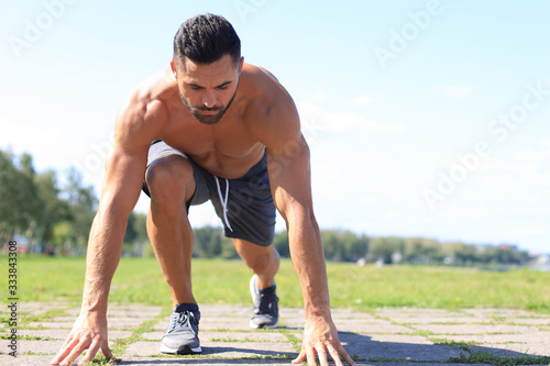 Athletic young man running in the nature. Concept of healthy lifestyle.