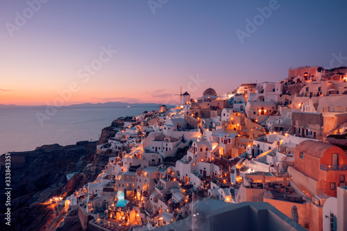 Beautiful view of fabulous picturesque village of Oia with traditional white houses and windmills in Santorini island at night, Greece © icemanphotos