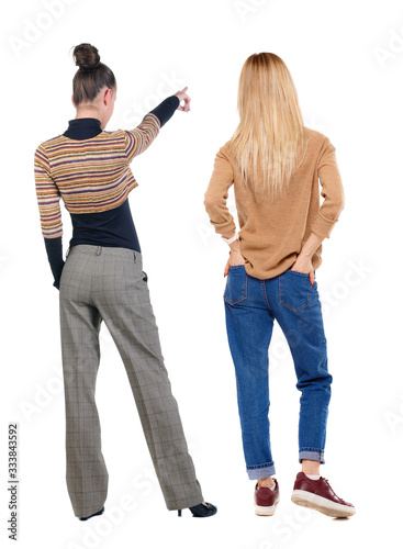 Back view of two pointing girl in sweater.