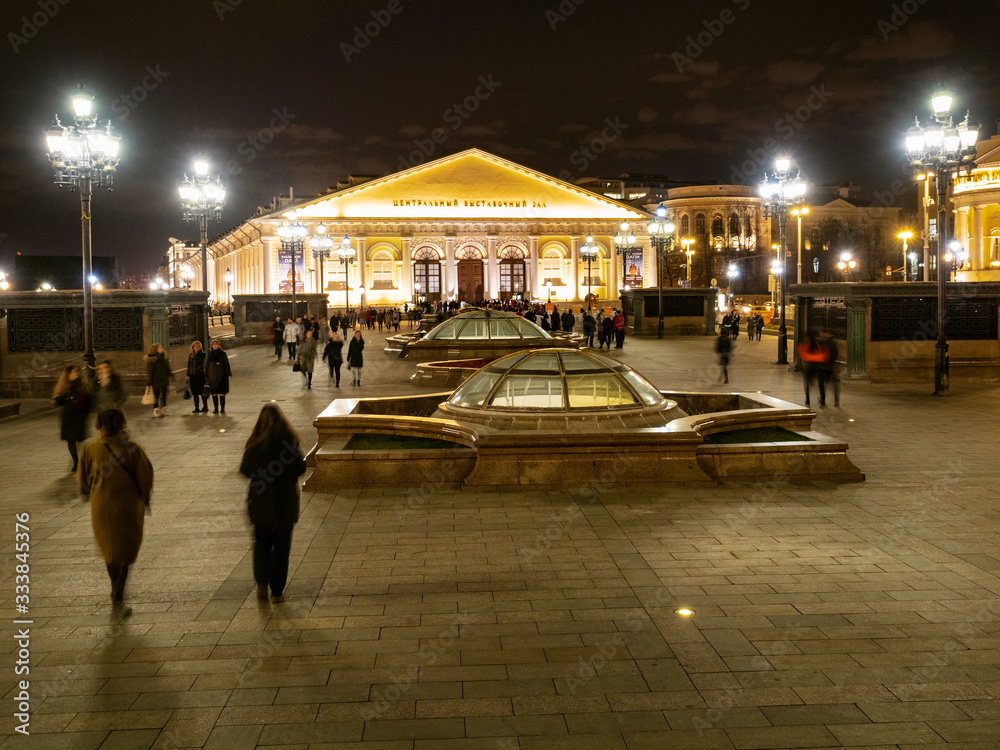visitors walk near Moscow Manege at night