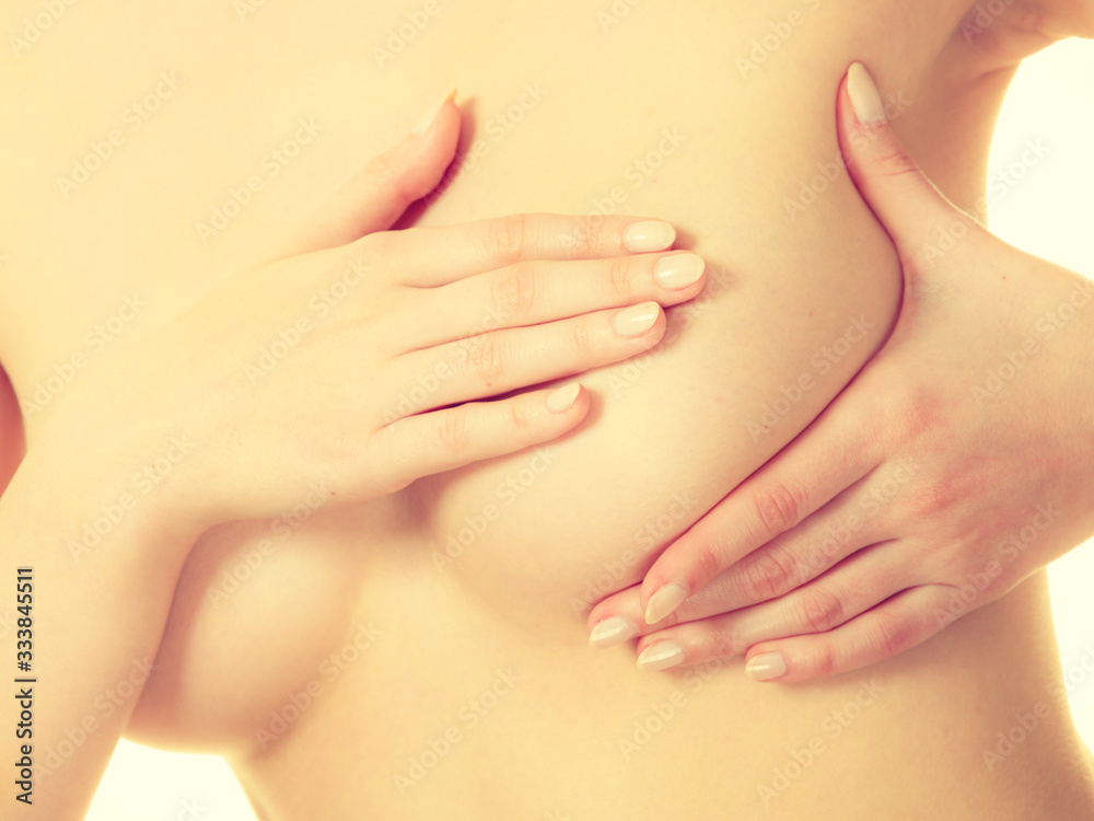 Fototapeta premium Woman examining her breasts for breast cancer