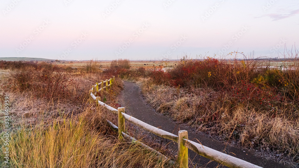 A view following the path past Rainham Marshes on a cloudy winter morning