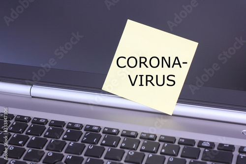 a piece of paper on a keyboard with the text "CORONA-VIRUS"