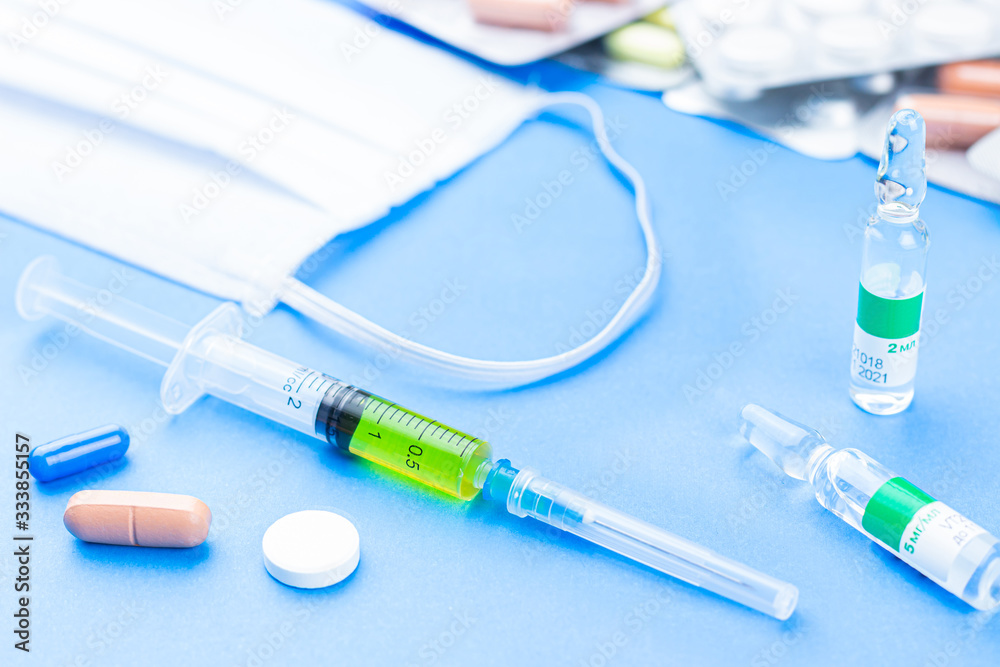 Pills, syringe, vaccine and breathing mask as a concept of coronavirus. Pills, syringe, vaccine and breathing mask as a concept of coronavirus.