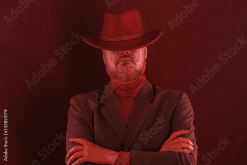 Studio shot closeup portrait of a bearded man in a red hat
