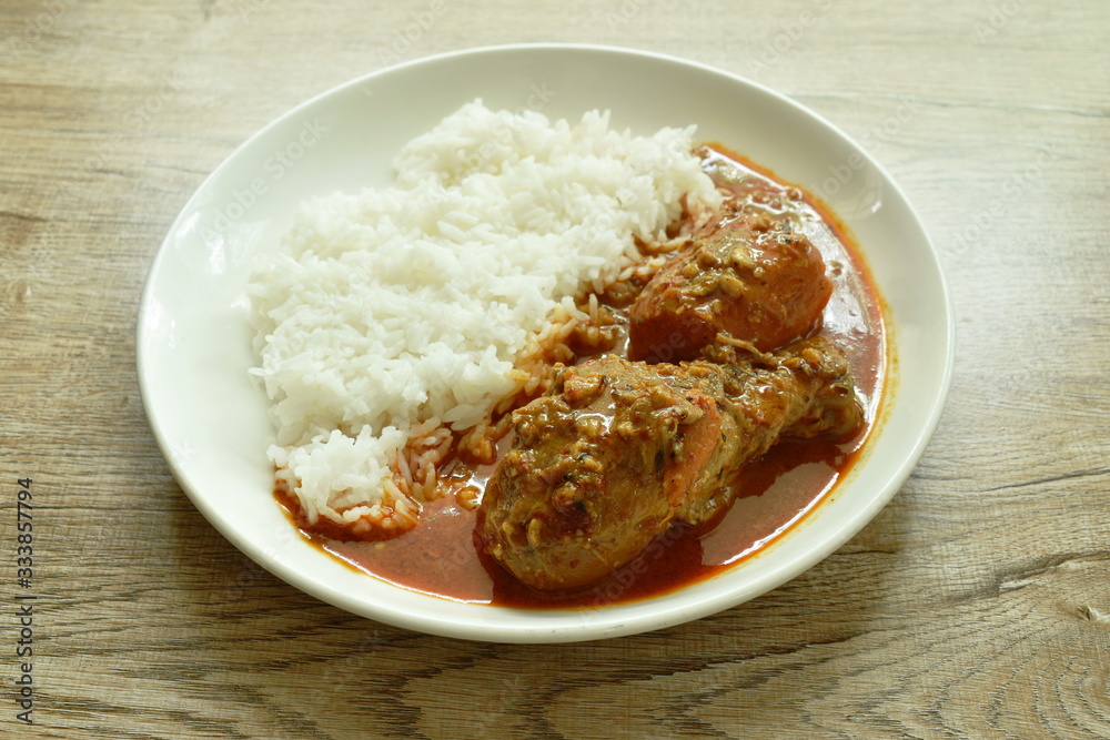 chicken leg spicy and sweet curry or mussaman eat with plain rice on dish chicken leg spicy and sweet curry or mussaman eat with plain rice on dish