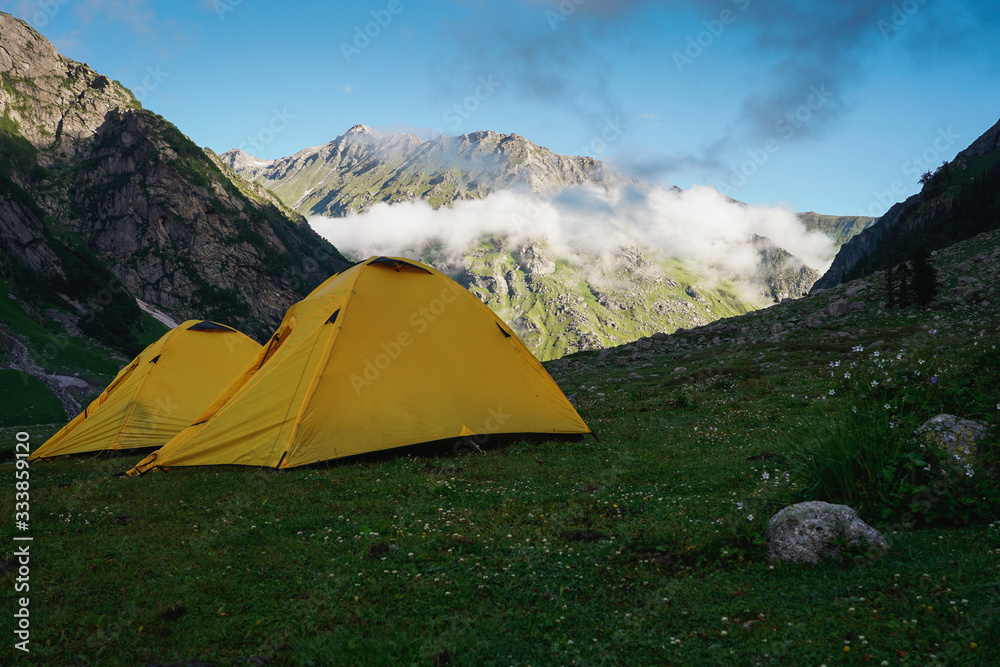 Yellow tents at Mulling campsite in Pin Bhaba pass trek in Shimla, Himalaya mountain range in north India