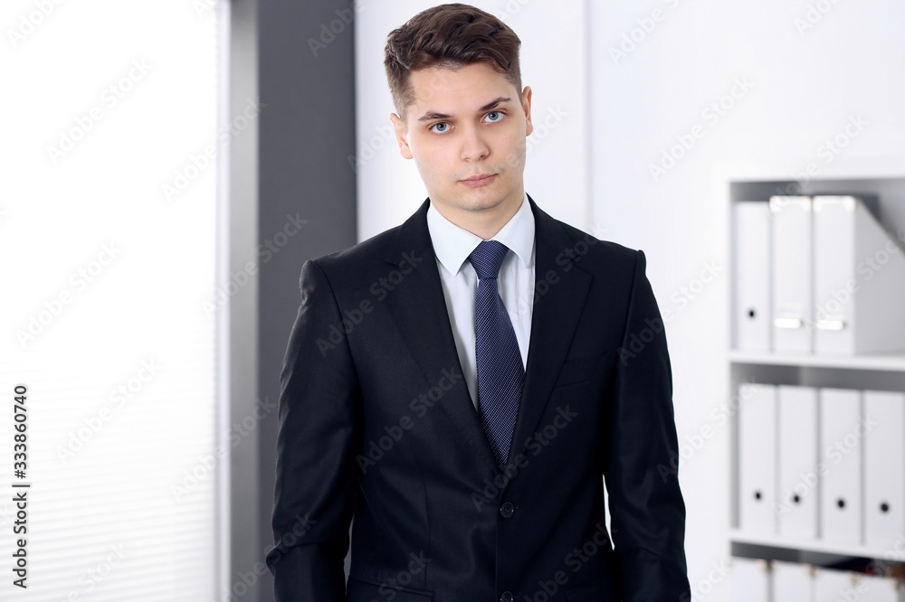 Businessman standing in office with arms crossed. Business concept Businessman standing in office with arms crossed. Business concept