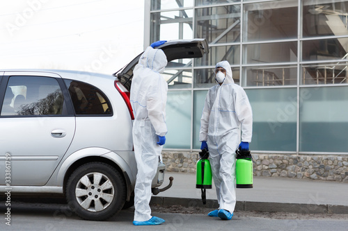 Man in hazmat suits buying disinfection spray for home cleaning © Prostock-studio