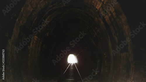 Exit from the dark railway tunnel. A light in the end of a tunnel. Freedom concept. This image brings about hope and strength