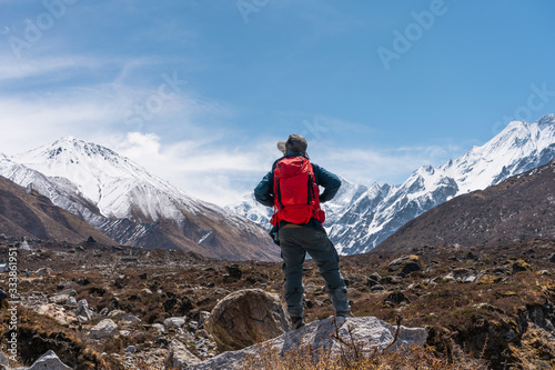A trekker with backpack trekking in Langtang valley, travelling in Himalya mountain range in Nepal