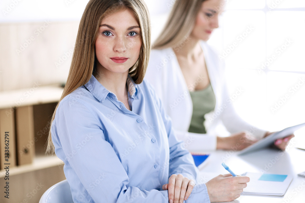 Business woman headshot. Businesspeople or colleagues discussing something at meeting while sitting at the desk in office. Audit, tax or lawyer concept Business woman headshot. Businesspeople or colleagues discussing something at meeting while sitting at the desk in office. Audit, tax or lawyer concept