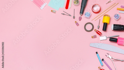 A set of cosmetic tools for manicure and pedicure on a white background. Gel polishes, nail files, manicure scissors, pusher and clippers top view. Composition for card with a place for text