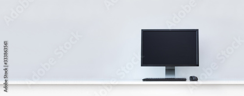 Clean white desk with computer and copy space.