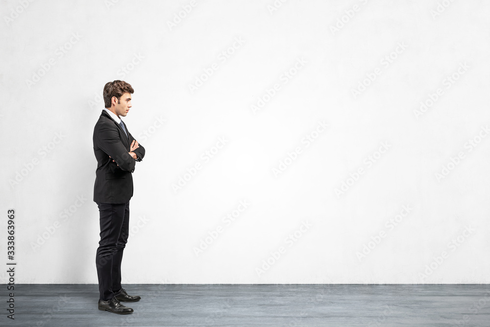Confident businessman near blank concrete wall Confident businessman near blank concrete wall