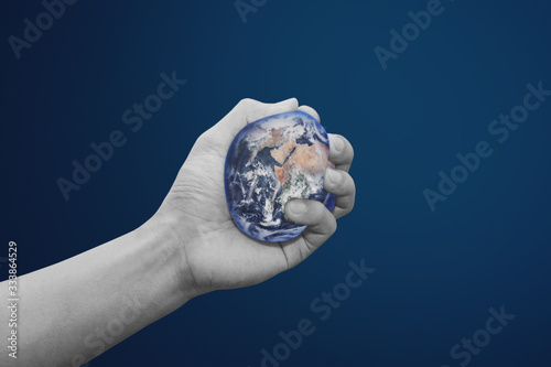 World crisis  and the world damaged by human hand concept. Earth has squeezing by human hand. Element of this image are furnished by NASA 