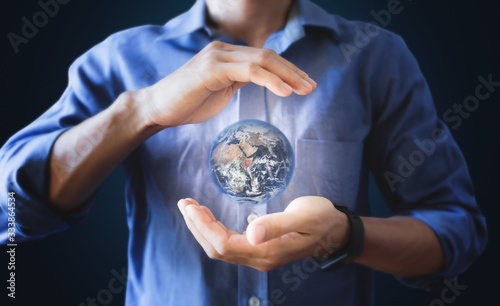 Fototapeta Naklejka Na Ścianę i Meble -  Earth day, saving energy, and protect the world concept. Earth holding by a man hand. Element of this image are furnished by NASA