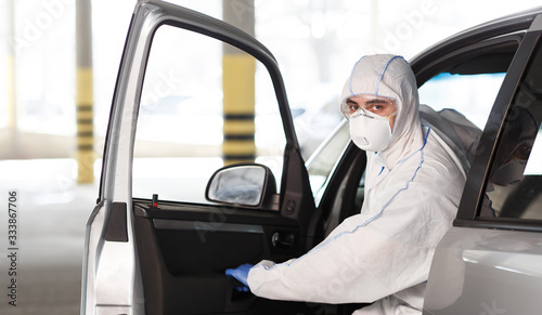 Man in coronavirus suit planning to drive by car photo