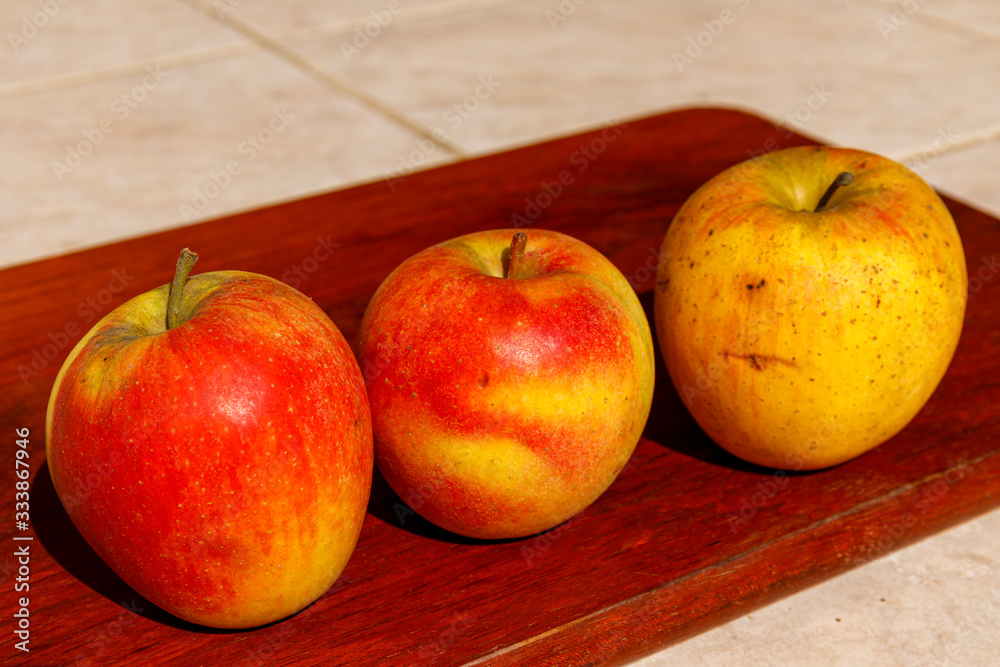 Fresh red organic apples on wooden table in summer day Fresh red organic apples on wooden table in summer day