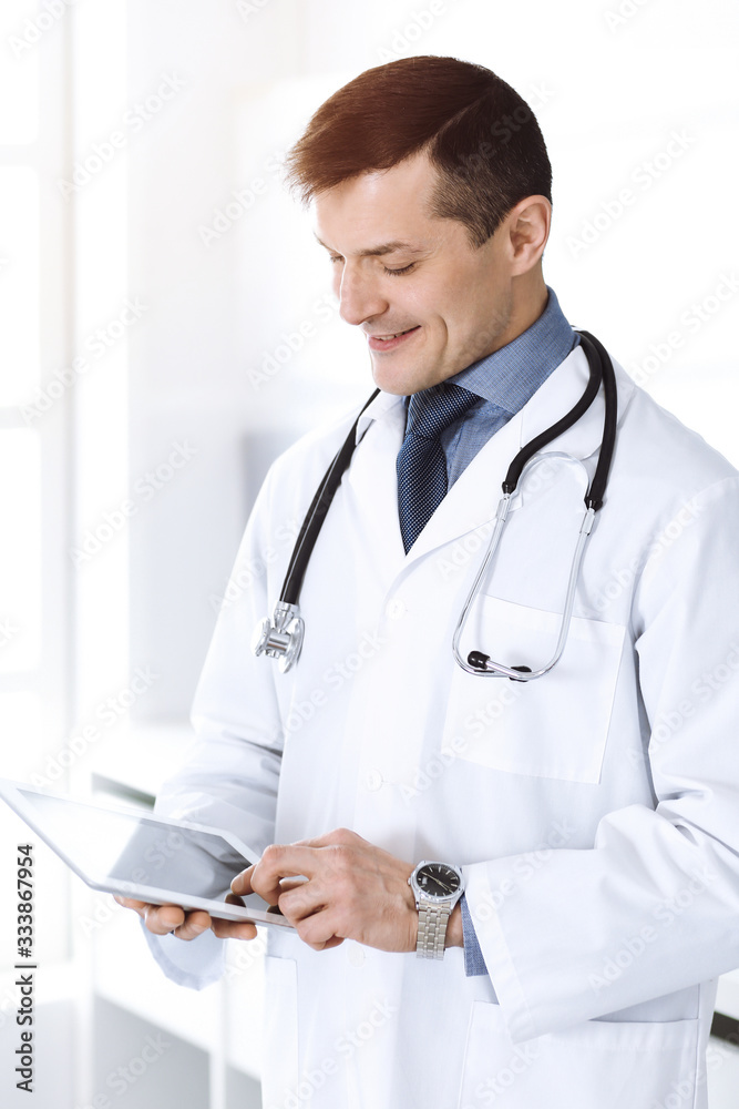 Doctor man using tablet computer for network research or virtual disease treatment. Perfect medical service in clinic. Happy future for modern medicine, medic data and healthcare concepts Doctor man using tablet computer for network research or virtual disease treatment. Perfect medical service in clinic. Happy future for modern medicine, medic data and healthcare concepts