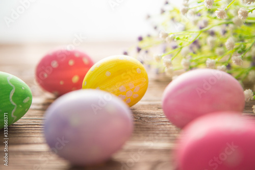 Colorful easter eggs with flowers on a old wooden surface
