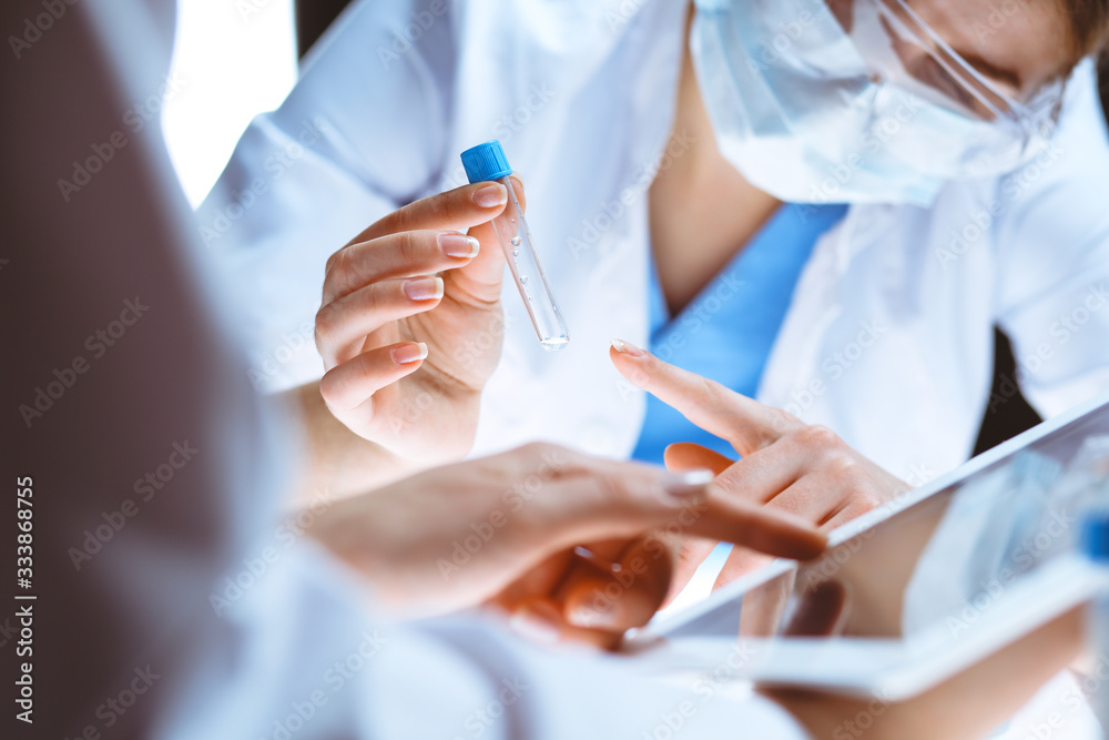 Coronavirus pandemic. Professional female scientist in protective eyeglasses researching tube in laboratory. Concepts of medicine and virus protection Coronavirus pandemic. Professional female scientist in protective eyeglasses researching tube in laboratory. Concepts of medicine and virus protection