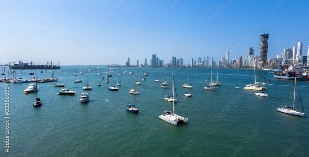 Cargo ship left port in Cartagena, Colombia. Beautiful yachts drift in the bay. Panorama The Bocagrande district in Cartagena.