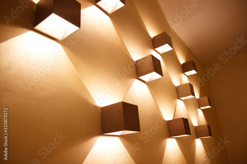 Fotografija Golden brown bronze color cube shaped sconces on a wall