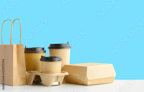 Assortment of food delivery containers on the table on blue wall background. Copy space.