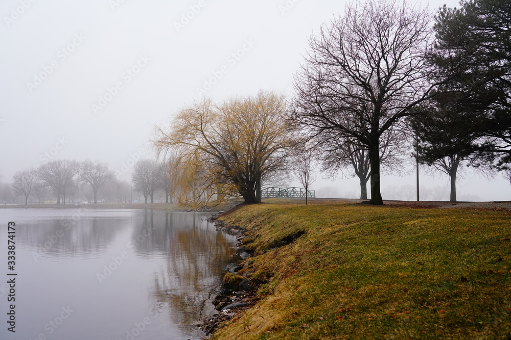Quiet community park covered in dense fog during cold winter to spring season day Quiet community park covered in dense fog during cold winter to spring season day