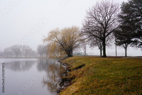 Quiet community park covered in dense fog during cold winter to spring season day © Aaron