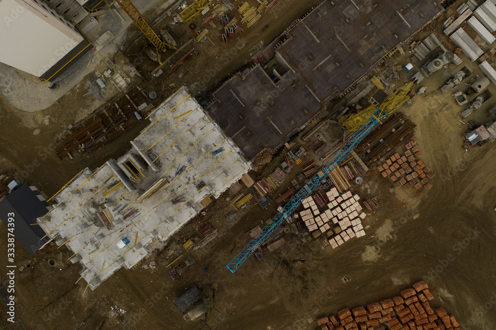 Construction and construction of high-rise buildings, the construction industry with working equipment and workers. View from above, from above. Background and texture Construction and construction of high-rise buildings, the construction industry with working equipment and workers. View from above, from above. Background and texture