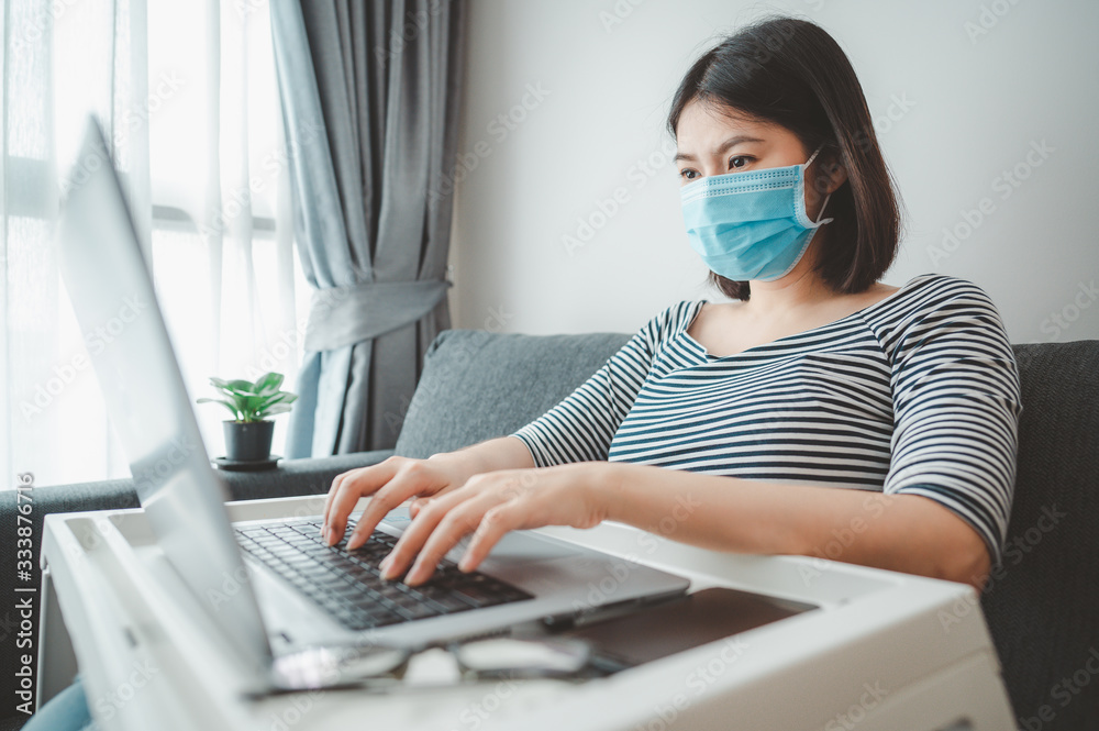 woman wearing face mask working at home woman wearing face mask working at home
