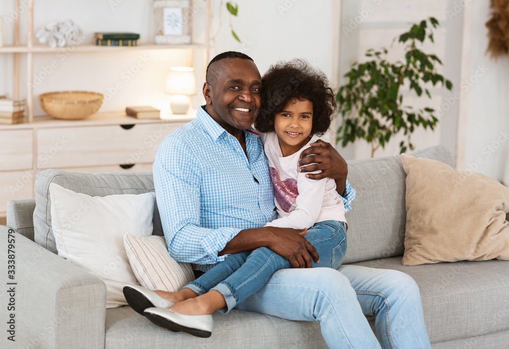 Stay at home concept. African American grandfather with his granddaughter spending time together indoors Stay at home concept. African American grandfather with his granddaughter spending time together indoors