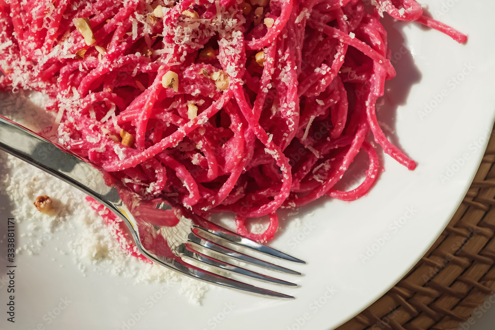 Spaghetti pasta with pink beetroot sause in a white bowl Spaghetti pasta with pink beetroot sause in a white bowl