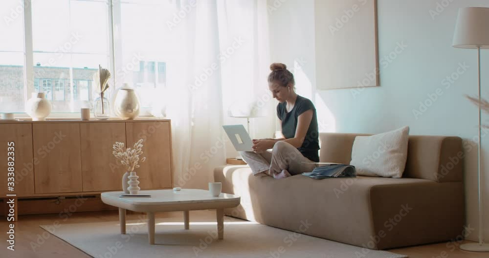 Caucasian female working on a laptop from home, having a video call on a sofa. Stay home, quarantine remote work. Shot on RED Dragon Caucasian female working on a laptop from home, having a video call on a sofa. Stay home, quarantine remote work. Shot on RED Dragon