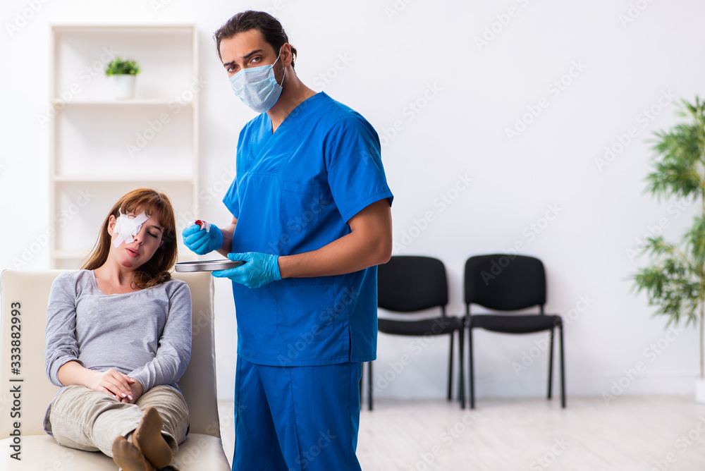 Fototapeta premium Young head injured woman visiting young male doctor