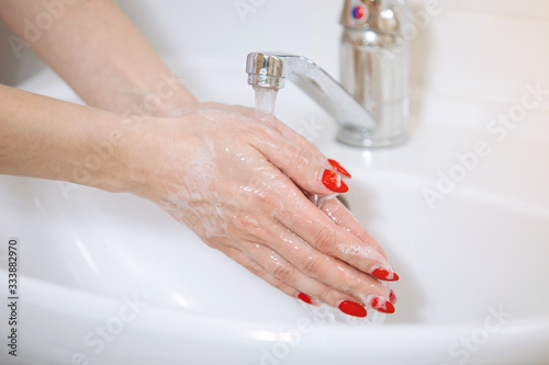 Woman washes hands.