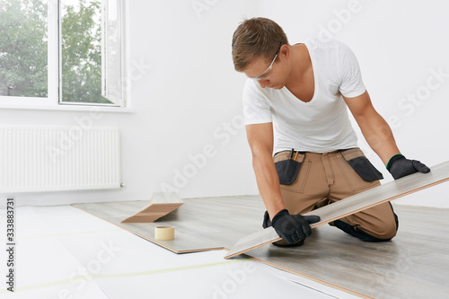 Master lays the laminate. Man installing new laminated wooden floor