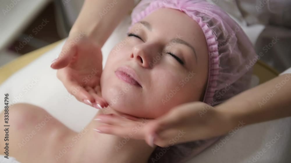 a girl doctor cosmetologist does an anti-aging facial massage for a young woman. close up a girl doctor cosmetologist does an anti-aging facial massage for a young woman. close up