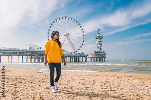 Fotografia woman on the beach of Schevening Netherlands during Spring, The Ferris Wheel The